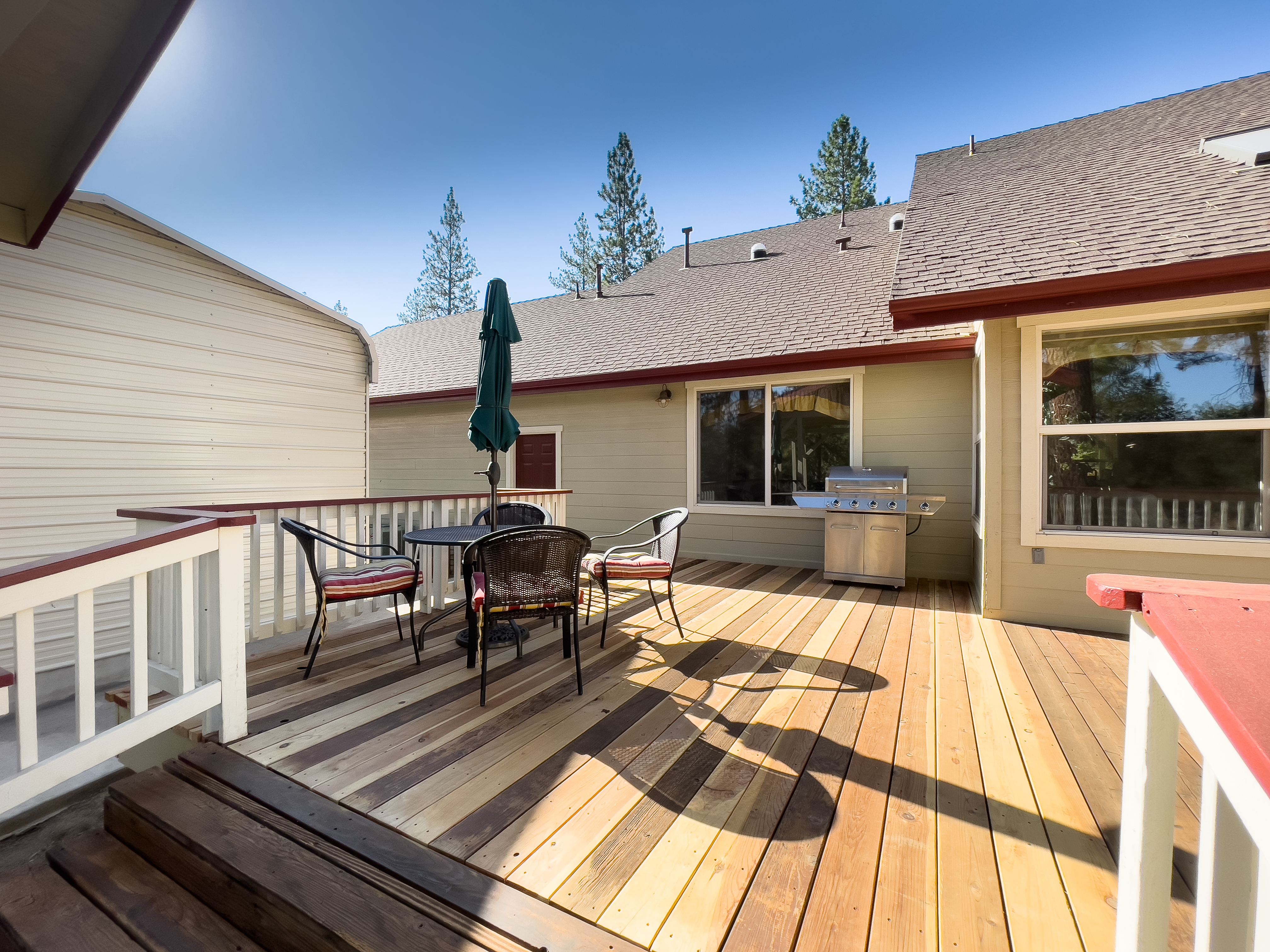 Deck with multiple seating areas and grill.